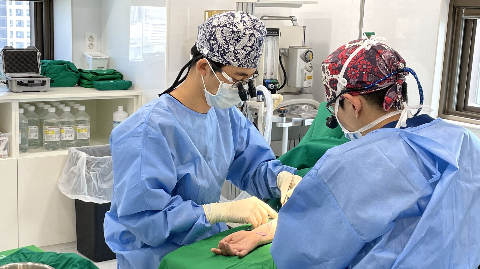 확대경을 쓰고 수술 중인 최진희 원장과 보조 의료진